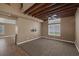 Carpeted living room area featuring exposed wood ceiling beams, neutral paint, and lots of natural light at 5816 Glory Canyon Way, Las Vegas, NV 89142