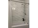 Bright bathroom featuring tub with white marble tiled walls and modern shower head fixture at 6432 Bannock Way, Las Vegas, NV 89107