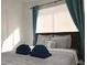 Comfortable bed in a well-lit bedroom with soft bedding and teal curtains at 6432 Bannock Way, Las Vegas, NV 89107