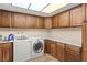 Well-organized laundry room with wooden cabinets, a sink, and modern washer and dryer at 6612 Elton Ave, Las Vegas, NV 89107