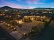 Expansive aerial view of the property at dusk, highlighting its illuminated driveway and meticulously landscaped grounds at 670 Du Fort Ave, Henderson, NV 89002
