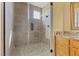 Modern bathroom showcasing a glass shower with tiled walls, granite counters, and wooden cabinets at 670 Du Fort Ave, Henderson, NV 89002