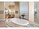 Bathroom showcasing a large tub with granite surround and glass block window at 670 Du Fort Ave, Henderson, NV 89002