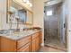 A bathroom boasting granite counters, wood cabinets, and a glass-enclosed shower with tiled walls at 670 Du Fort Ave, Henderson, NV 89002