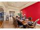 Well-lit dining room with a traditional wooden table, plush chairs, and a vibrant red accent wall at 670 Du Fort Ave, Henderson, NV 89002
