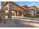 Stately home exterior featuring stone accents, porte-cochere, and lush landscaping at 670 Du Fort Ave, Henderson, NV 89002