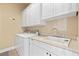 A functional laundry area with ample storage, a sink, and a modern washer and dryer setup at 670 Du Fort Ave, Henderson, NV 89002