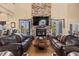 Bright living room featuring a stone fireplace, large couches, and access to the outdoors at 670 Du Fort Ave, Henderson, NV 89002