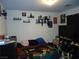 Bedroom featuring a large TV, decor shelves, and dim lighting at 6772 Oak Mist St, Las Vegas, NV 89139