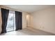 Neutral bedroom with gray floors and patio access through sliding glass door at 6861 Tamarus St # 203, Las Vegas, NV 89119