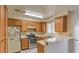 Traditional kitchen with stainless steel appliances, light countertops, and wood cabinets at 6861 Tamarus St # 203, Las Vegas, NV 89119