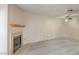 Cozy living room with modern flooring, neutral walls, fireplace, and a ceiling fan at 6861 Tamarus St # 203, Las Vegas, NV 89119