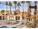 Community pool with chairs and palm trees perfect for relaxation at 6861 Tamarus St # 203, Las Vegas, NV 89119