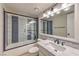 Updated bathroom with marble countertop, glass shower door, and modern lighting fixture at 7633 Raven Hills Dr, Las Vegas, NV 89149