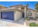 Charming home exterior with tile roof, blue garage door, and desert landscaping at 7633 Raven Hills Dr, Las Vegas, NV 89149