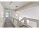Upstairs hallway with modern railing leads to bedrooms and additional living spaces at 7633 Raven Hills Dr, Las Vegas, NV 89149