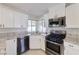 Modern kitchen with white cabinets, stainless steel appliances, and granite countertops at 7633 Raven Hills Dr, Las Vegas, NV 89149