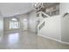 Open-concept living room with stairs, tile flooring, and natural light at 7633 Raven Hills Dr, Las Vegas, NV 89149