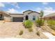 Inviting single-story home features desert landscaping, brick driveway, and a charming covered entryway at 80 Cathedral Wash Pl, Henderson, NV 89011
