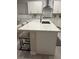 Kitchen island with white cabinets and seating with a quartz countertop at 80 Cathedral Wash Pl, Henderson, NV 89011