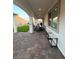 An outdoor living space features brick pavers, covered patio and partial view of the green space at 80 Cathedral Wash Pl, Henderson, NV 89011