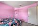 Comfortable pink bedroom featuring carpeted floors, soft lighting, and a cozy tropical-themed bedspread at 8048 Astrology Ct # 201, Las Vegas, NV 89128