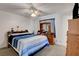 Comfortable bedroom with a ceiling fan, wooden dresser with mirror, and a blue patterned comforter at 8048 Astrology Ct # 201, Las Vegas, NV 89128