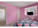 Bright pink bedroom featuring carpeted floors, soft lighting, and a tropical-themed bedspread at 8048 Astrology Ct # 201, Las Vegas, NV 89128