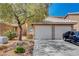 Charming townhome featuring a two-car garage, desert landscaping, and a tile roof at 8048 Astrology Ct # 201, Las Vegas, NV 89128
