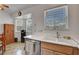 Bright kitchen features a stainless steel dishwasher, white countertops, and natural light from a large window at 8048 Astrology Ct # 201, Las Vegas, NV 89128