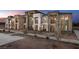 A row of stylish townhouses with stone accents, balconies, and well-maintained landscaping at 871 Apatite Pl # Lot 54, Henderson, NV 89011