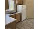 A bright kitchen featuring tile floors, white appliances, wood cabinets, and a sink under a window at 9000 Las Vegas Blvd # 2189, Las Vegas, NV 89123