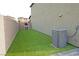 Side yard with synthetic lawn, paver border and an air conditioning unit at 9648 Spyglass Run Ave, Las Vegas, NV 89178