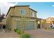 Side view of a two-story house featuring a two-car garage and a brick driveway at 9648 Spyglass Run Ave, Las Vegas, NV 89178
