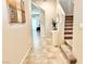 Neutral-toned hallway with tile flooring leading to an upstairs staircase and dining area at 9648 Spyglass Run Ave, Las Vegas, NV 89178