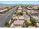Expansive aerial view of a community with neatly lined houses, wide streets, and mountain views on a sunny day at 10164 Village Breeze Pl, Las Vegas, NV 89183