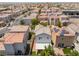 Aerial view of a residential neighborhood featuring uniform houses with well-maintained backyards and tile roofs at 10164 Village Breeze Pl, Las Vegas, NV 89183