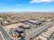 Aerial shot of a commercial area with businesses and a gas station in a residential neighborhood, under a clear blue sky at 10164 Village Breeze Pl, Las Vegas, NV 89183