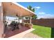 Covered back patio with an outdoor kitchen, patio furniture, and a small grass yard at 10164 Village Breeze Pl, Las Vegas, NV 89183