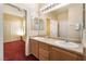 Bathroom featuring a double sink vanity, a large mirror, and access to the bedroom at 10164 Village Breeze Pl, Las Vegas, NV 89183