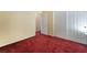 Bedroom featuring plush red carpeting, pale yellow walls, and an open closet for easy storage at 10164 Village Breeze Pl, Las Vegas, NV 89183