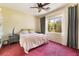 Comfortable bedroom with a ceiling fan, large window, and carpeted floor at 10164 Village Breeze Pl, Las Vegas, NV 89183