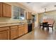 Open kitchen with wooden cabinetry, black appliances, and a dining area with backyard views at 10164 Village Breeze Pl, Las Vegas, NV 89183