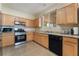 Bright kitchen with wooden cabinets, black appliances, and ample counter space for cooking at 10164 Village Breeze Pl, Las Vegas, NV 89183