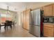 Bright kitchen showcasing stainless steel refrigerator, wooden cabinets, and adjacent dining area at 10164 Village Breeze Pl, Las Vegas, NV 89183