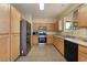 Well-equipped kitchen with stainless steel appliances, wooden cabinets, and ample counter space at 10164 Village Breeze Pl, Las Vegas, NV 89183