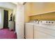 Bright laundry room featuring a washer, a dryer, and shelving for convenient storage at 10164 Village Breeze Pl, Las Vegas, NV 89183