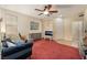 Bright living room featuring a ceiling fan, carpet flooring, and natural light at 10164 Village Breeze Pl, Las Vegas, NV 89183