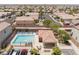 Aerial view of a neighborhood pool and recreation area with ample seating and lush landscaping at 10164 Village Breeze Pl, Las Vegas, NV 89183