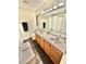 Bathroom featuring double sinks, wood cabinets, and a shower at 10500 Horseshoe Falls Ct, Las Vegas, NV 89144